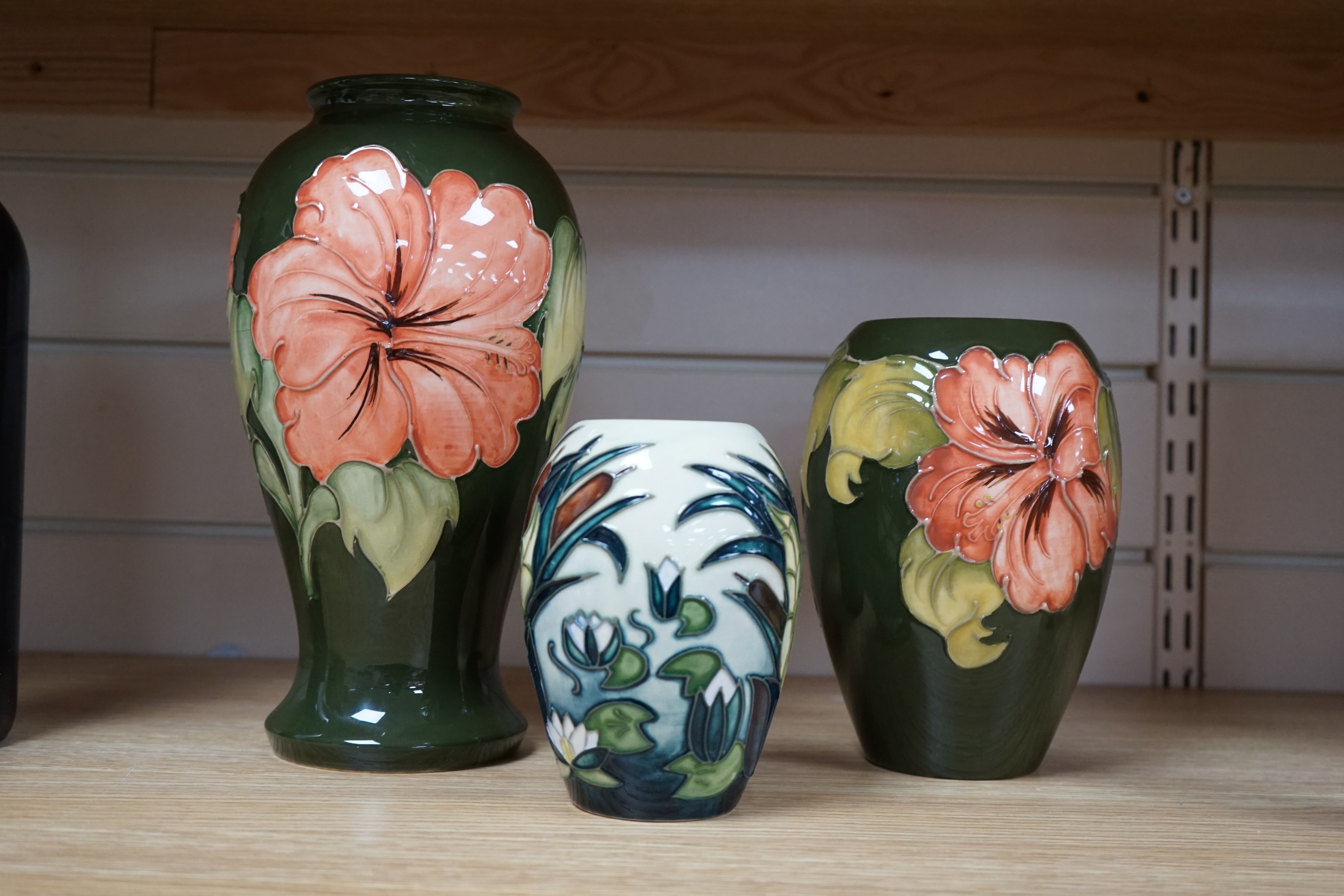 Three 1990's Moorcroft vases, Hibiscus and Lamia pattern, tallest 26cm. Condition - good